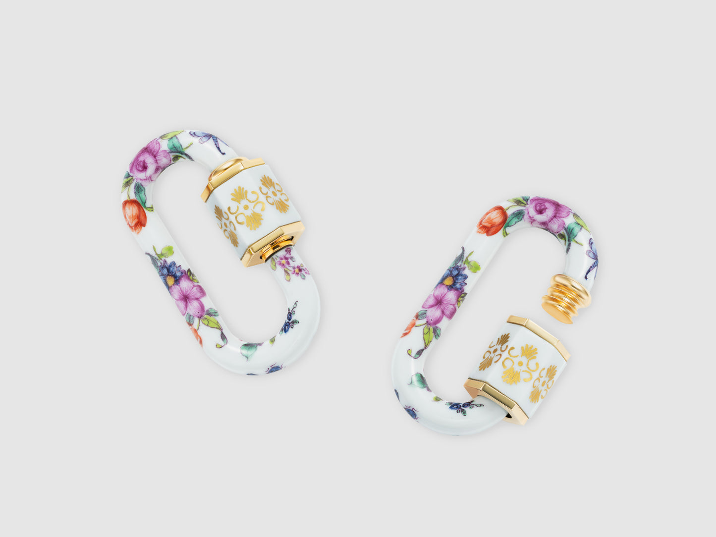Porzellan-Schlösser mit handbemaltem Blumenmuster, hexagonaler Hülse und goldfarbenen Details, Draufsicht.
Pair of porcelain locks with hand-painted floral pattern, hexagonal sleeve and gold-tone accents, top view.