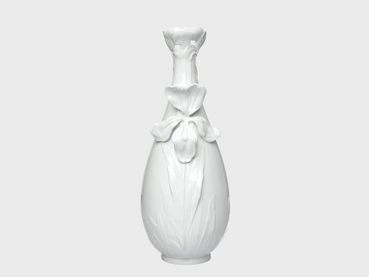 Weiße Porzellanvase mit glänzender Oberfläche und floralen Reliefdetails auf neutral hellgrauem Hintergrund. Die bauchige Form wird durch eine große Blütenapplikation auf der Vorderseite und eine dekorativ geformte, blütenartige Öffnung am Hals ergänzt.
White porcelain vase with a glossy finish and floral relief details on a neutral light gray background. The rounded body features a large flower applique on the front, while the neck is finished with a decorative, blossom-shaped opening.