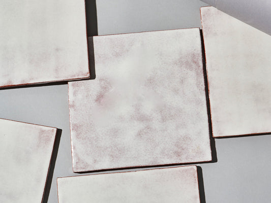 Majolika-Fliese mit durchschimmernder weißer Glasur und changierender Oberfläche.
Majolica tile with translucent white glaze and subtly shifting surface tones