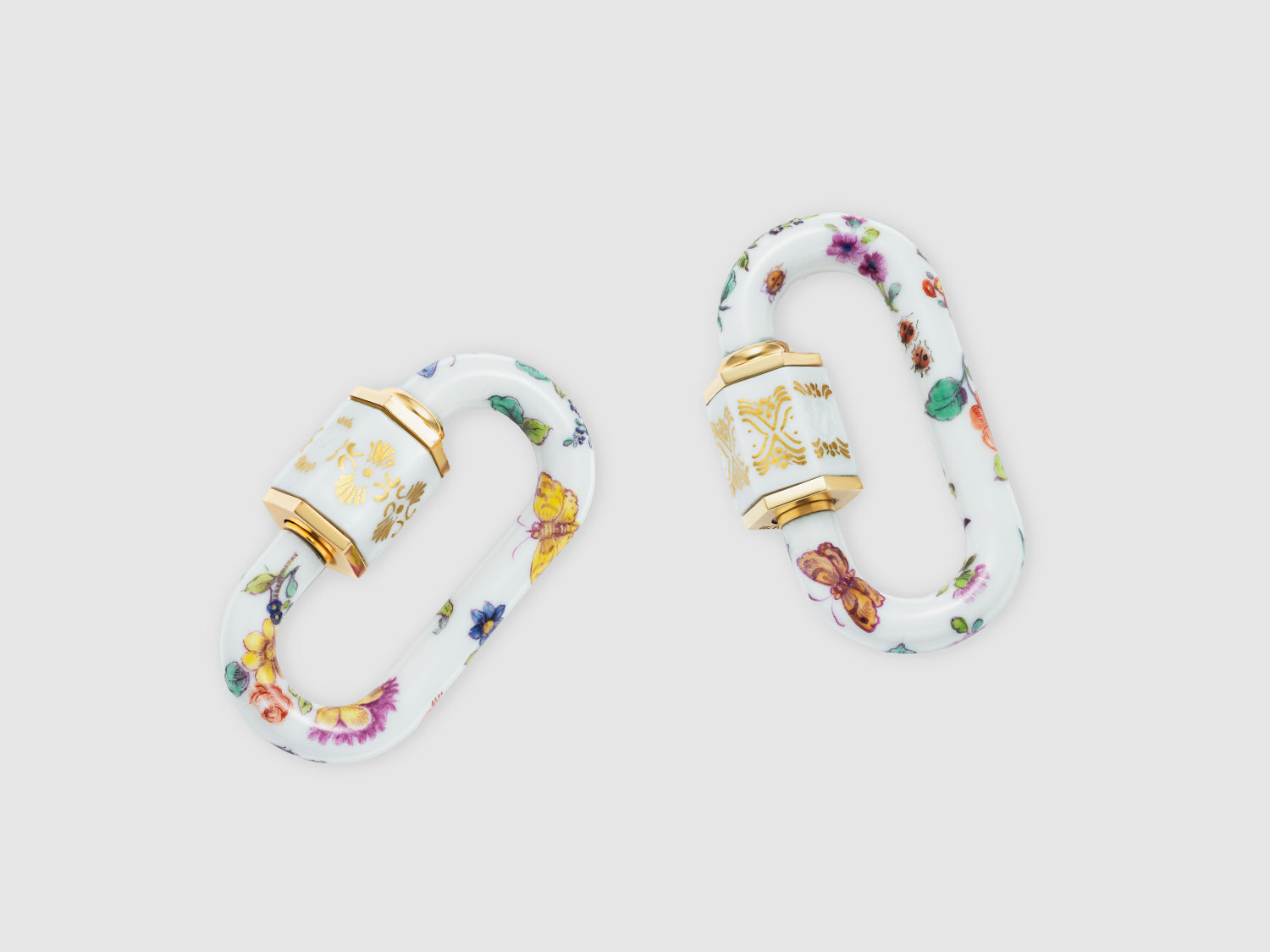 Zwei Porzellan-Schlösser mit violett-roten Blüten, Schmetterlings- und Beerenmotiven; feine Goldornamente auf der Hülse.

Two porcelain locks with purple-red blossoms, butterfly and berry motifs; delicate gold ornament on the sleeve.