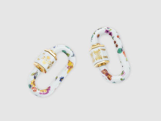 Zwei Porzellan-Schlösser mit violett-roten Blüten, Schmetterlings- und Beerenmotiven; feine Goldornamente auf der Hülse.

Two porcelain locks with purple-red blossoms, butterfly and berry motifs; delicate gold ornament on the sleeve.