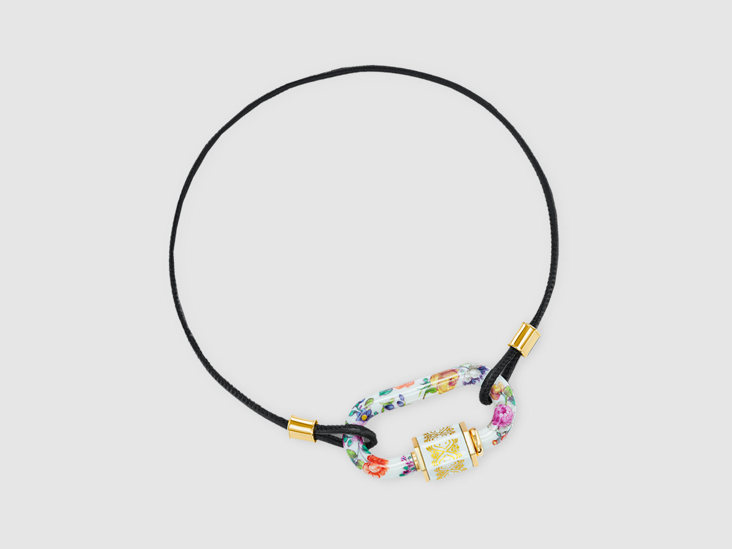 Halsband mit Porzellan-Schloss am schwarzen Band, goldfarbene Endhülsen; Marla Aaron x Nymphenburg.

Necklace with porcelain lock on a black cord, gold-tone end caps; Marla Aaron x Nymphenburg.