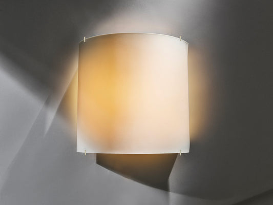 Beleuchtete Wandleuchte „Luna Pure“ aus weißem Biskuitporzellan, warm leuchtend vor grauer Wand.

Illuminated “Luna Pure” wall light made of white biscuit porcelain, glowing warmly against a grey wall.
