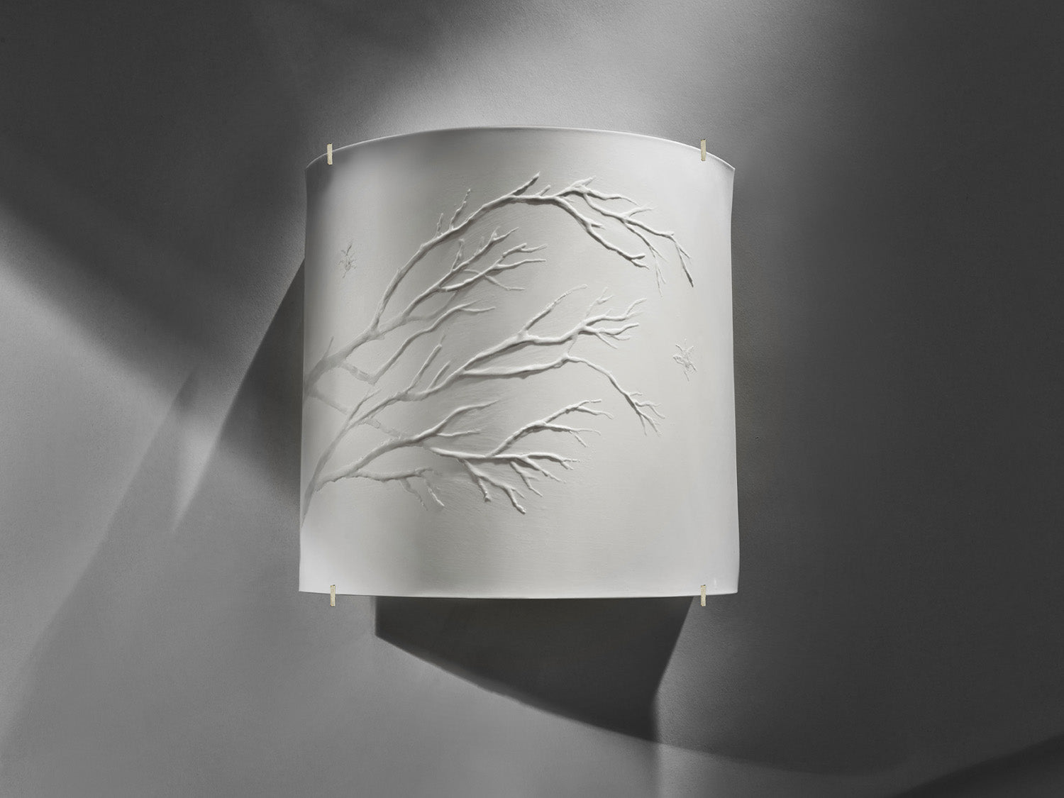 Wandleuchte aus weißem Biskuitporzellan mit eingeprägtem Zweigrelief, Licht aus.

White biscuit porcelain wall lamp with embossed branch relief, light off.